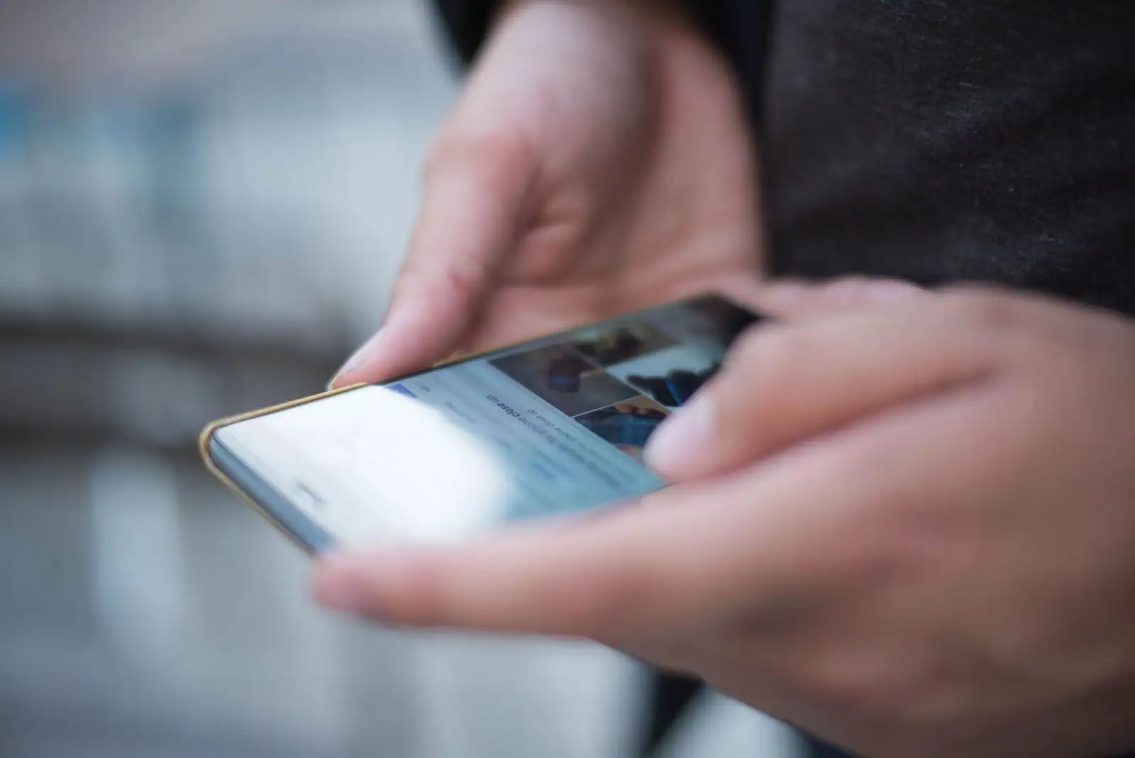 Personne lisant l'actualité en continu sur l'écran d'un smartphone, application d'information ouverte