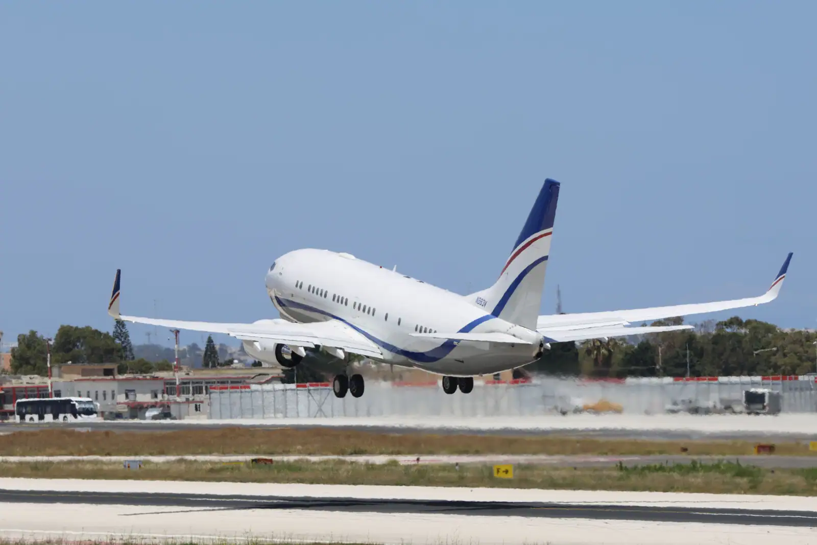 Avion de ligne monocouloir décollant de la piste d'un aéroport sous un ciel dégagé