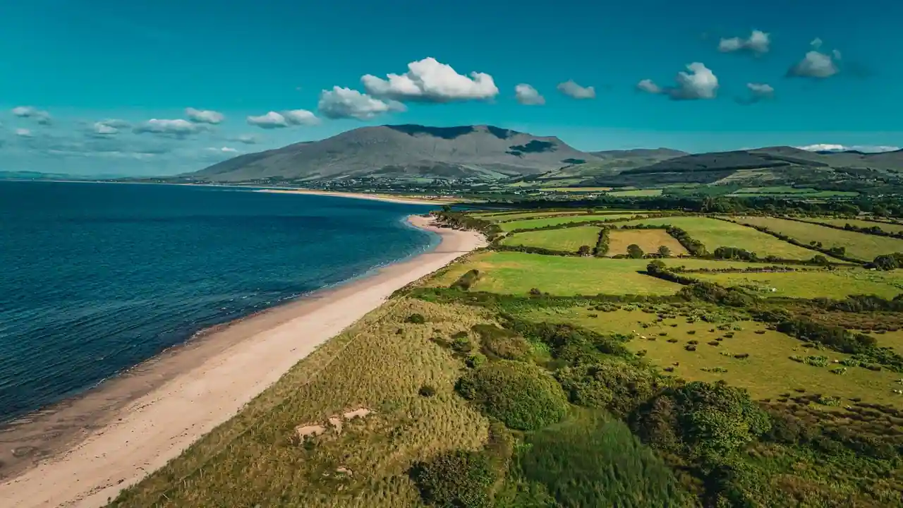 Longue plage de sable bordée de collines verdoyantes sur une côte atlantique