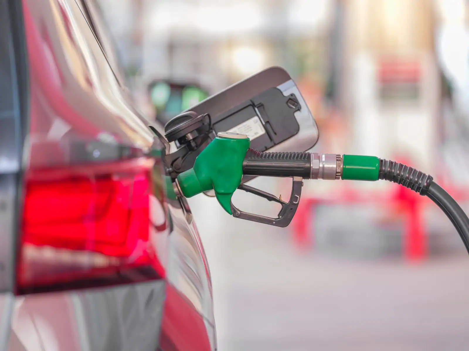Pistolet de pompe à carburant inséré dans le réservoir d'une voiture en station-service
