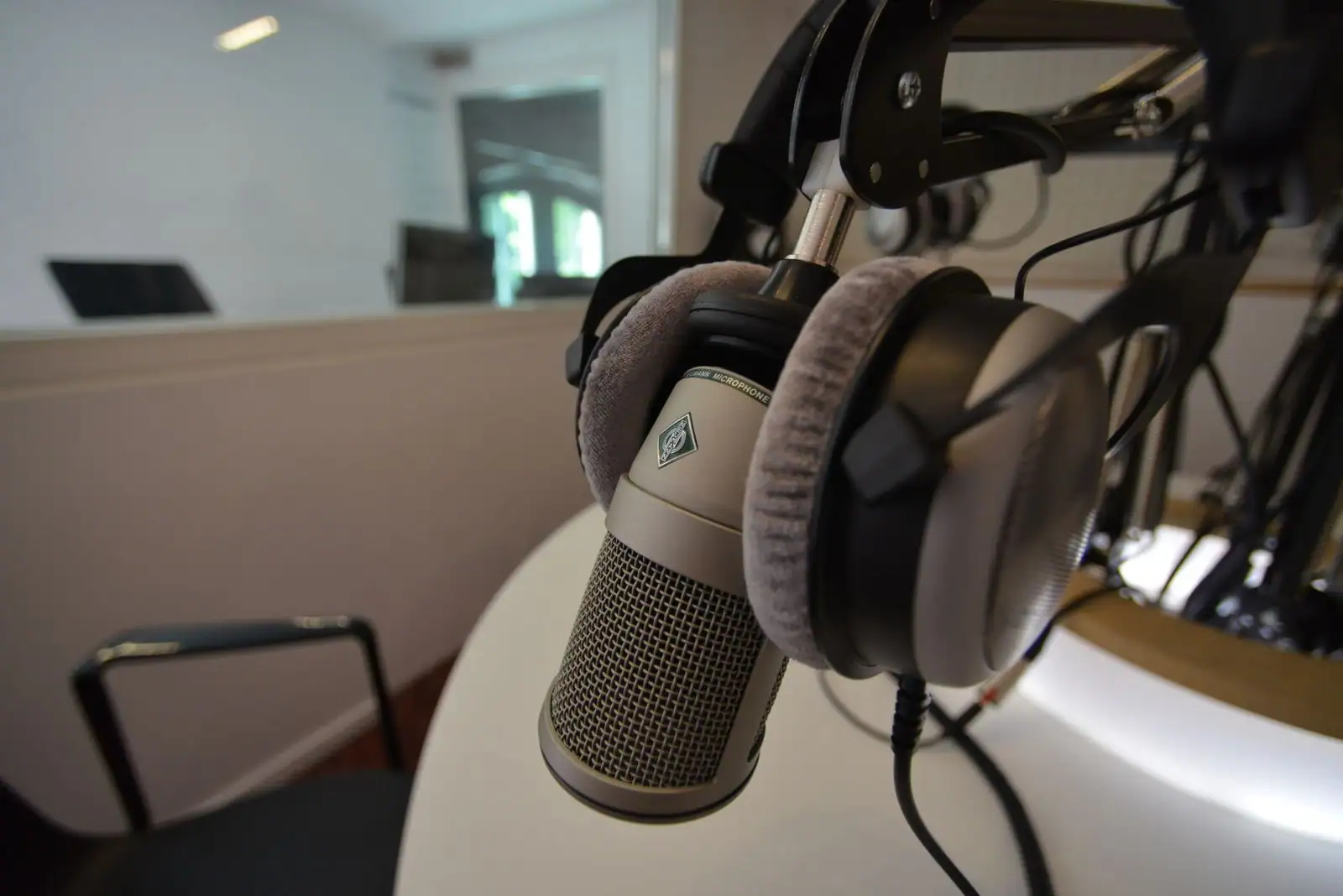 Micro de studio professionnel et casque audio suspendu, dans une cabine d'enregistrement.