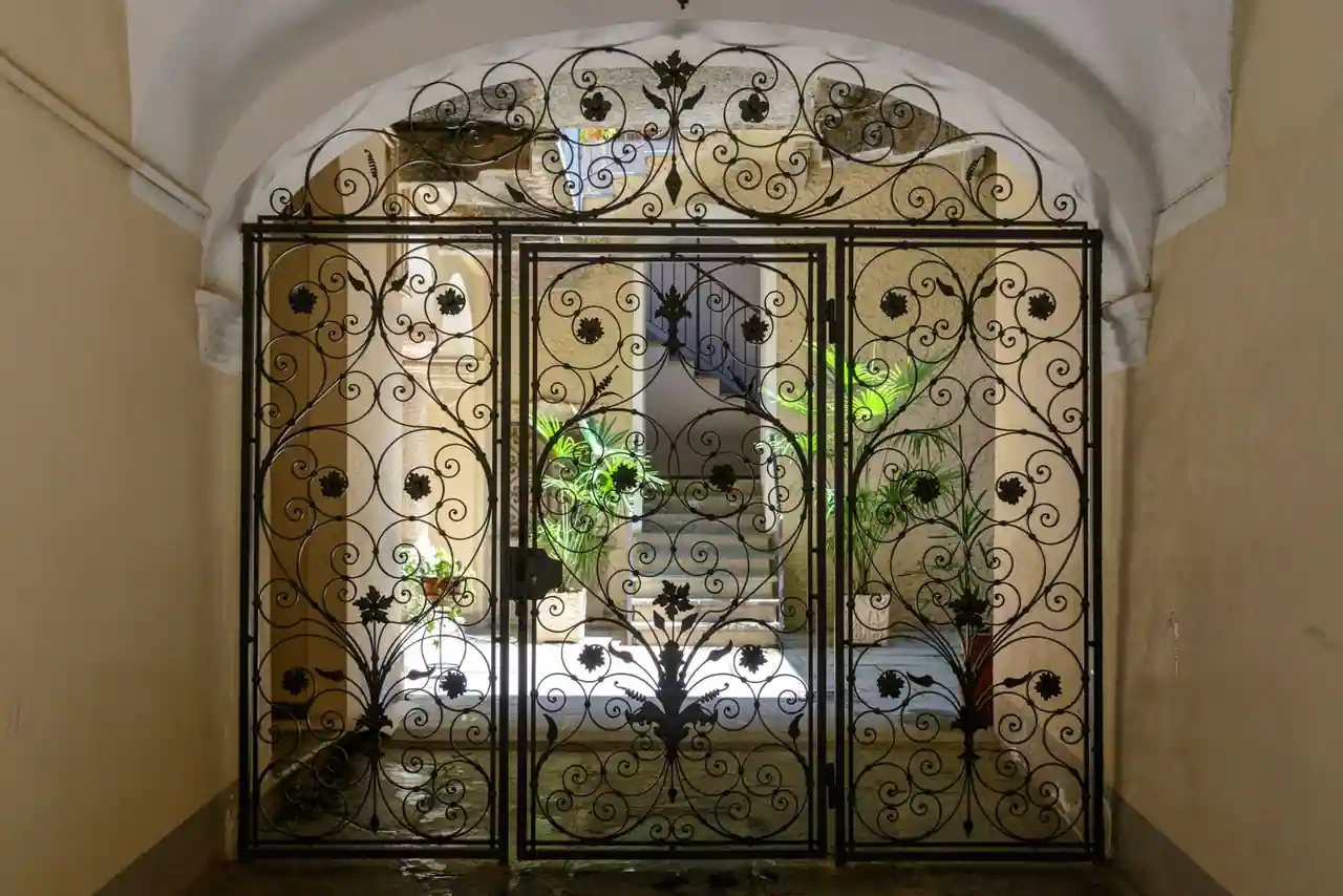 Grille ouvragée en fer fermée à l'entrée d'une cour