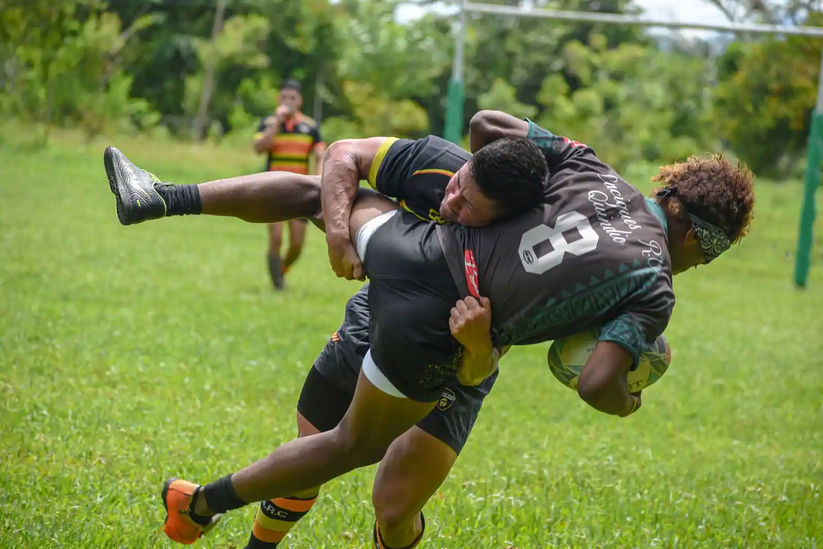 Plaquage au contact lors d'un match de rugby sur une pelouse, le porteur de ballon stoppé net