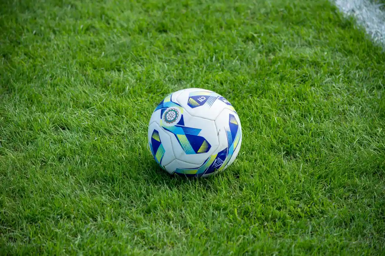 Ballon de football posé sur la pelouse verte d'un stade