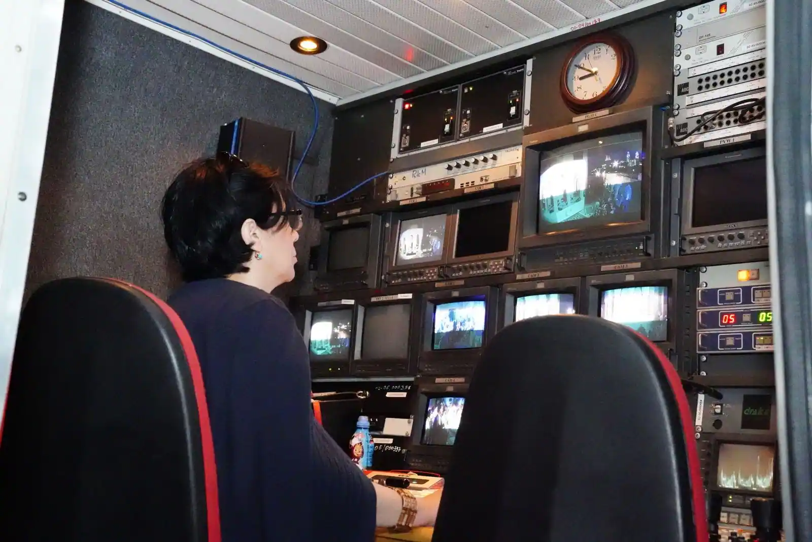 Régie d'une chaîne de télévision : un opérateur face à un mur d'écrans contrôlant une diffusion en direct.