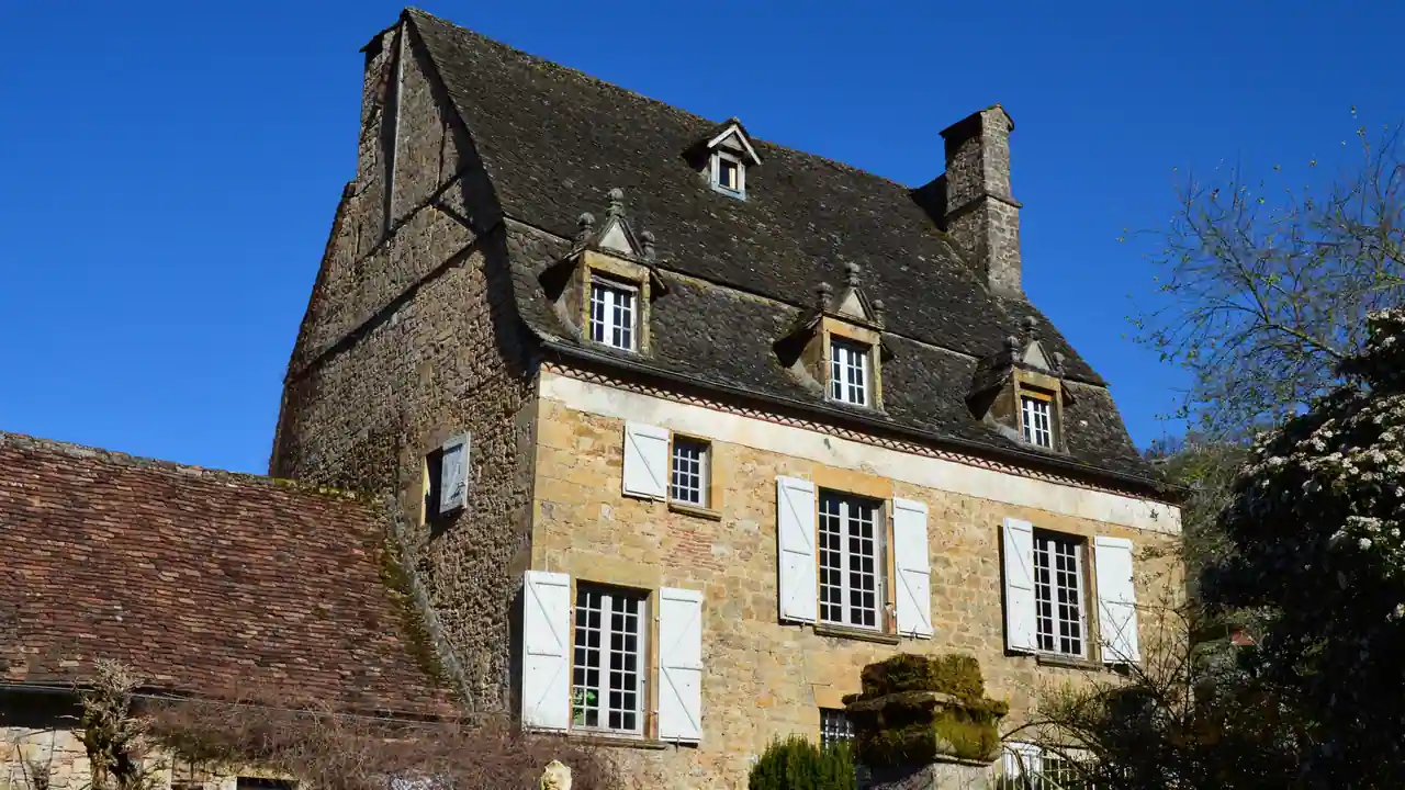 Maison de campagne française en pierre dorée aux volets clairs, typique d'un gîte rural