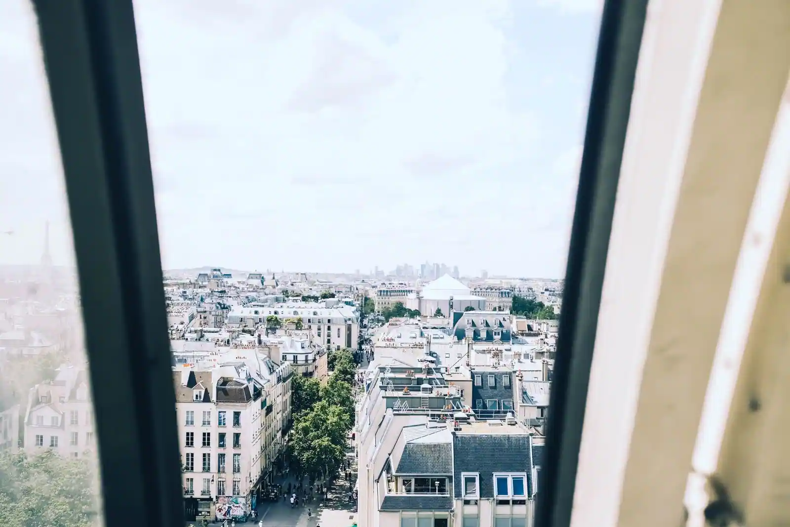 Vue sur les toits de Paris depuis une fenêtre en hauteur, image d'illustration.