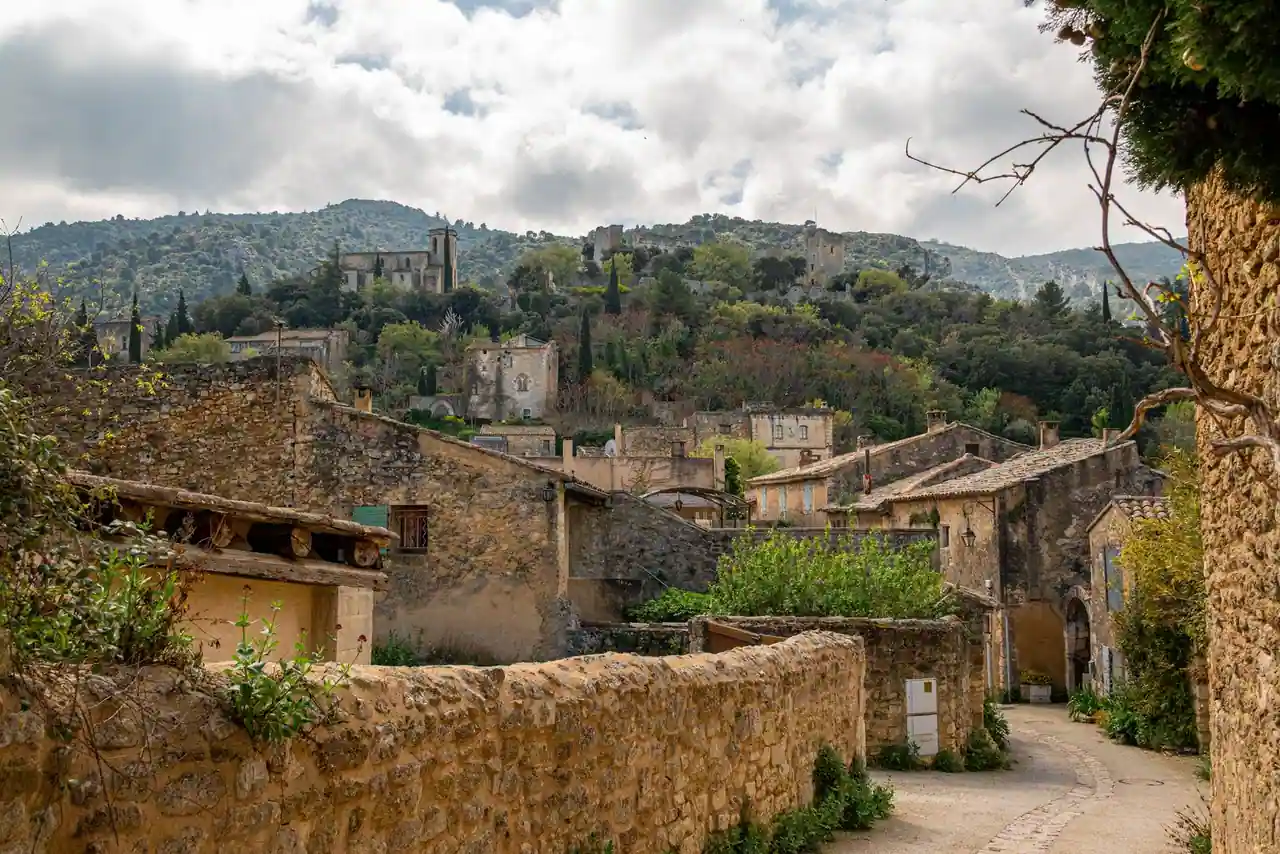 Village provençal en pierre niché dans des collines boisées, typique de l'arrière-pays méditerranéen