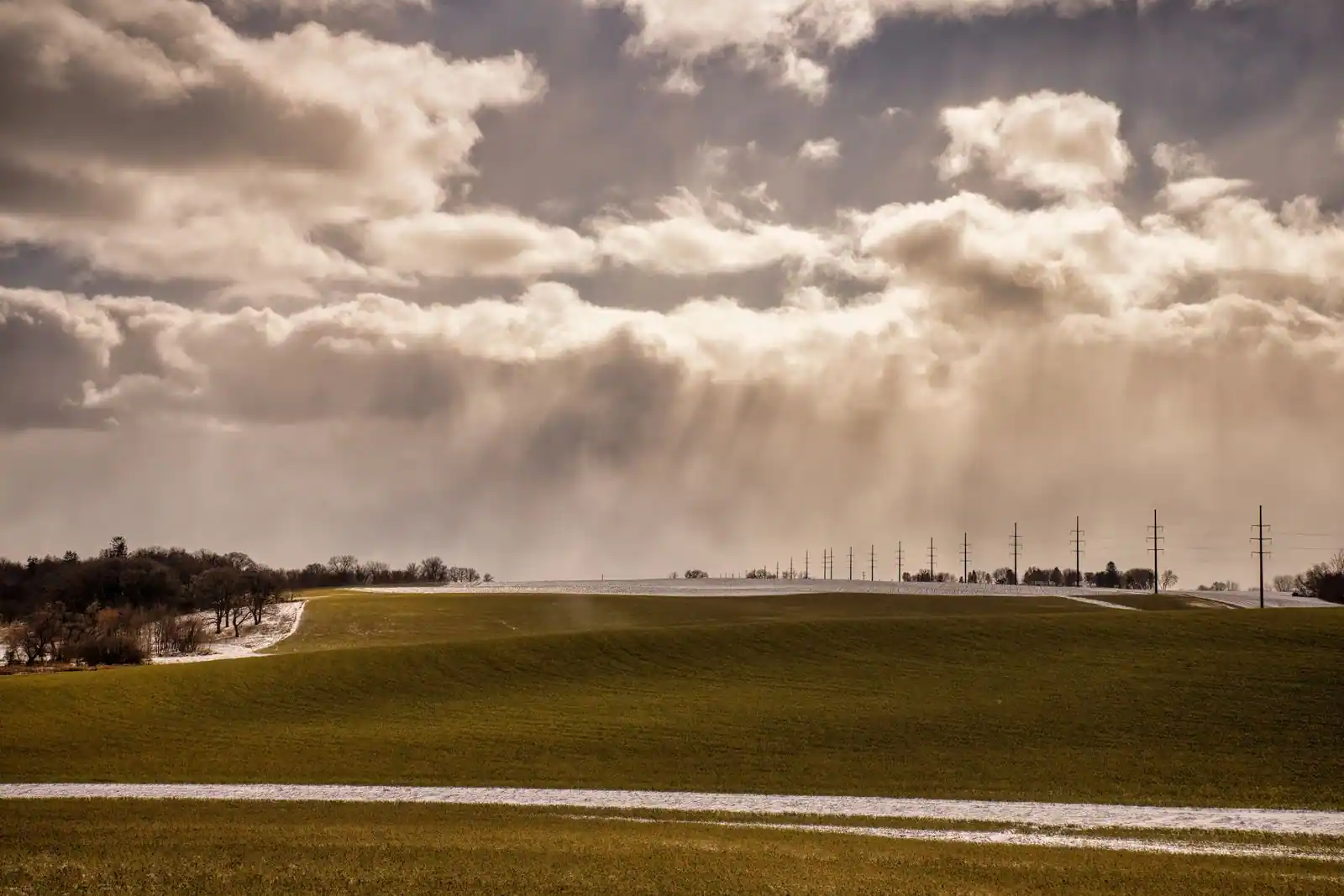 Un paysage de campagne sous un ciel changeant, entre éclaircies et nuages, typique d'un climat tempéré.