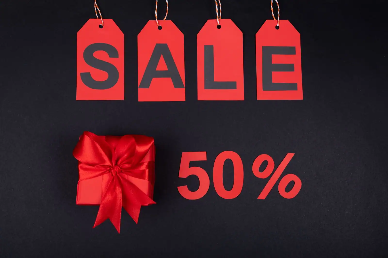 Étiquettes de réduction rouges « SALE » sur fond sombre, illustration d'une promotion