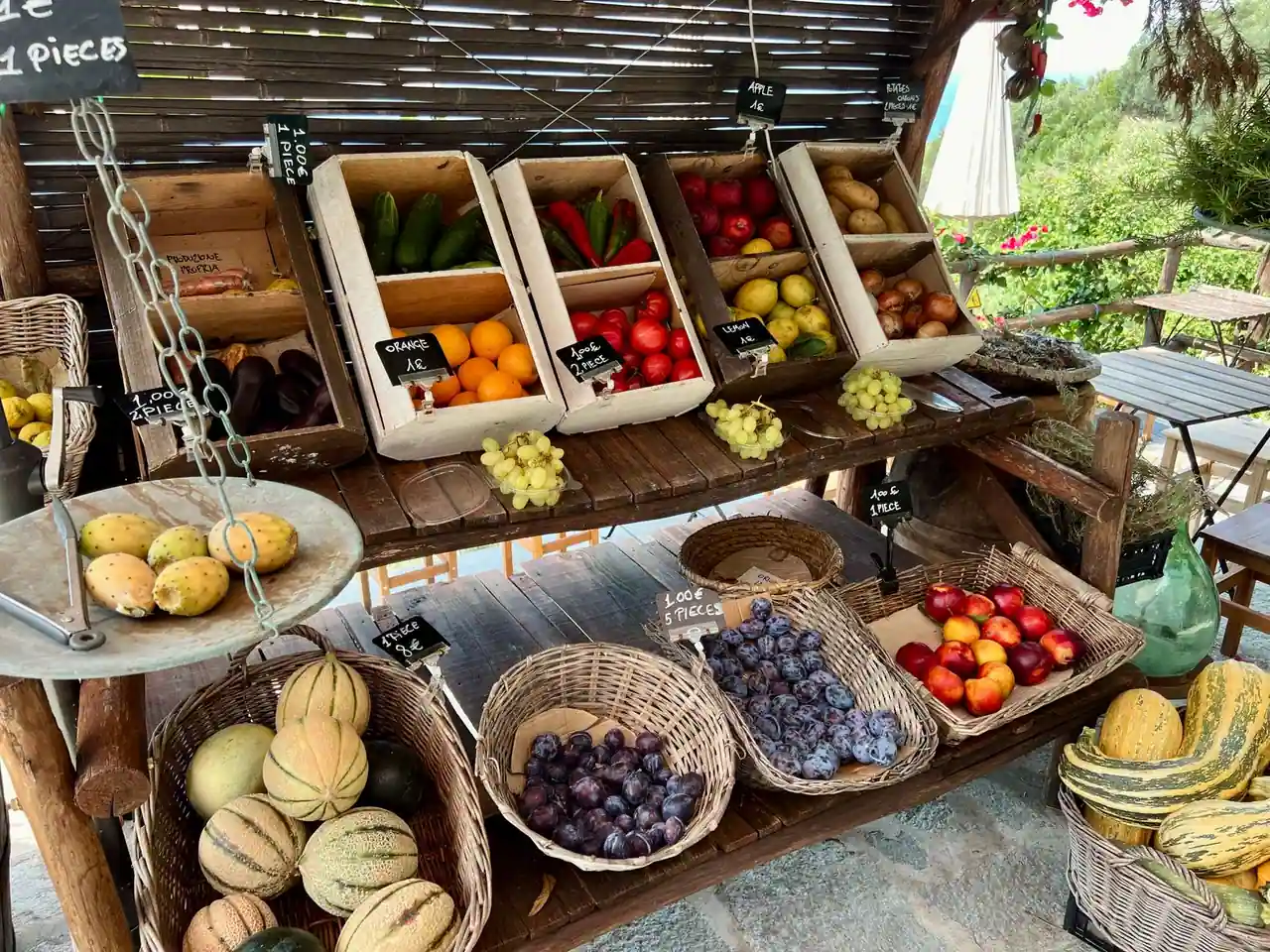 Étal de fruits et légumes de saison disposés dans des cagettes et paniers en bois sur un marché de producteur