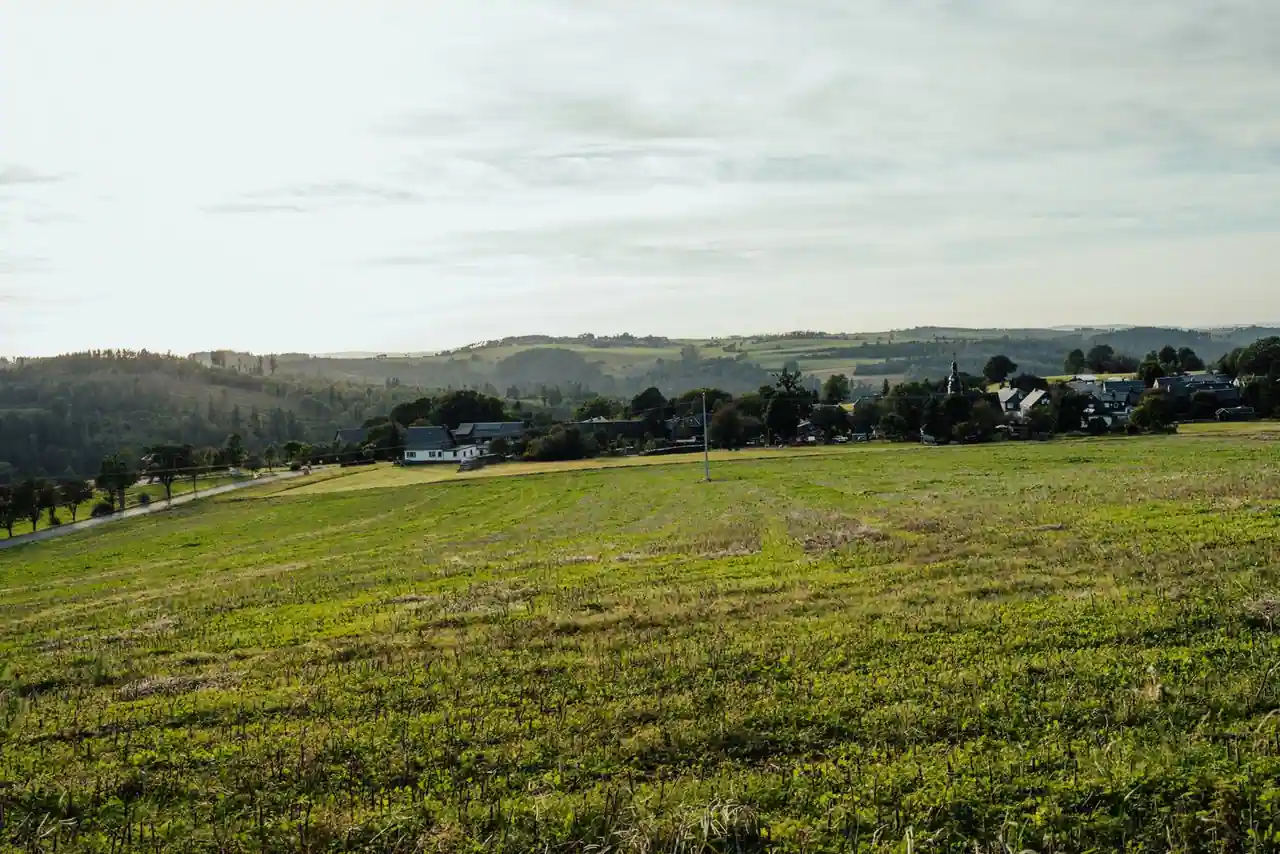 Paysage de campagne française avec un village niché entre des collines