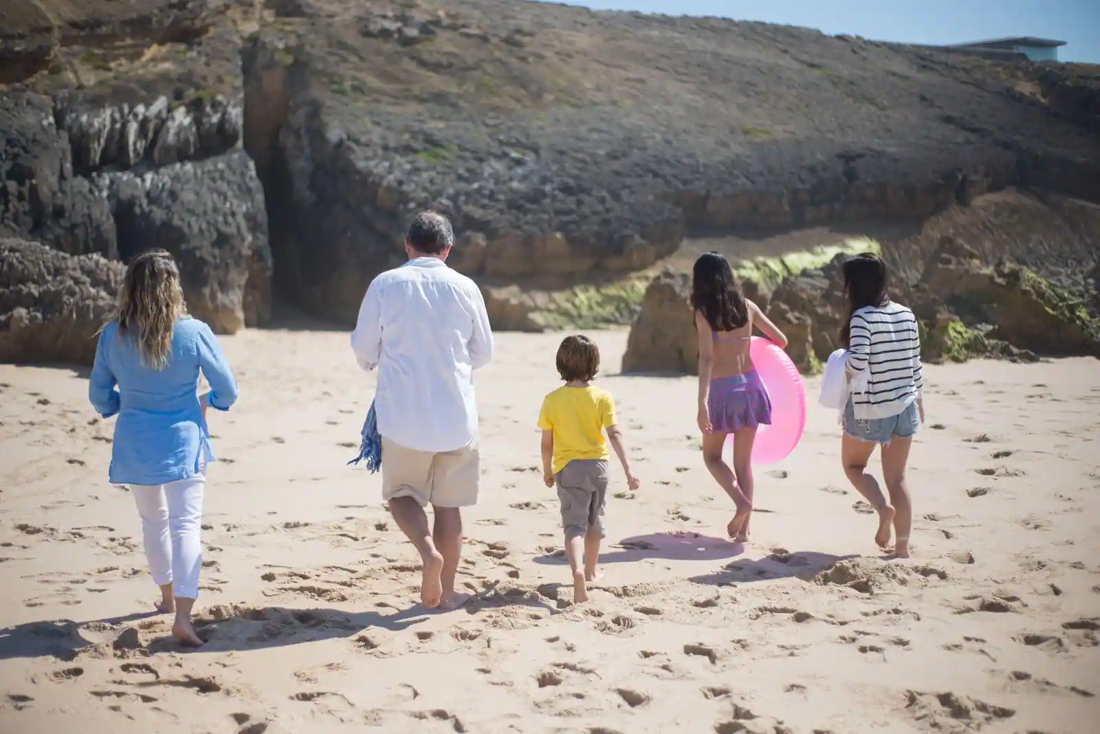 Famille marchant ensemble sur une plage pendant les vacances