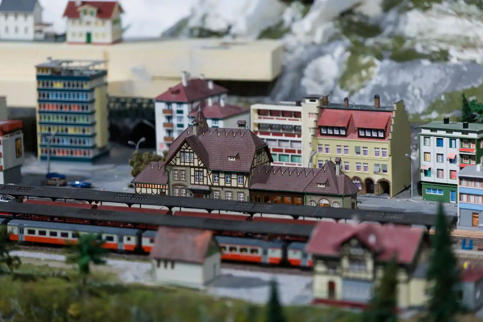 Maquettes de bâtiments et trains miniatures dans un décor de modélisme détaillé