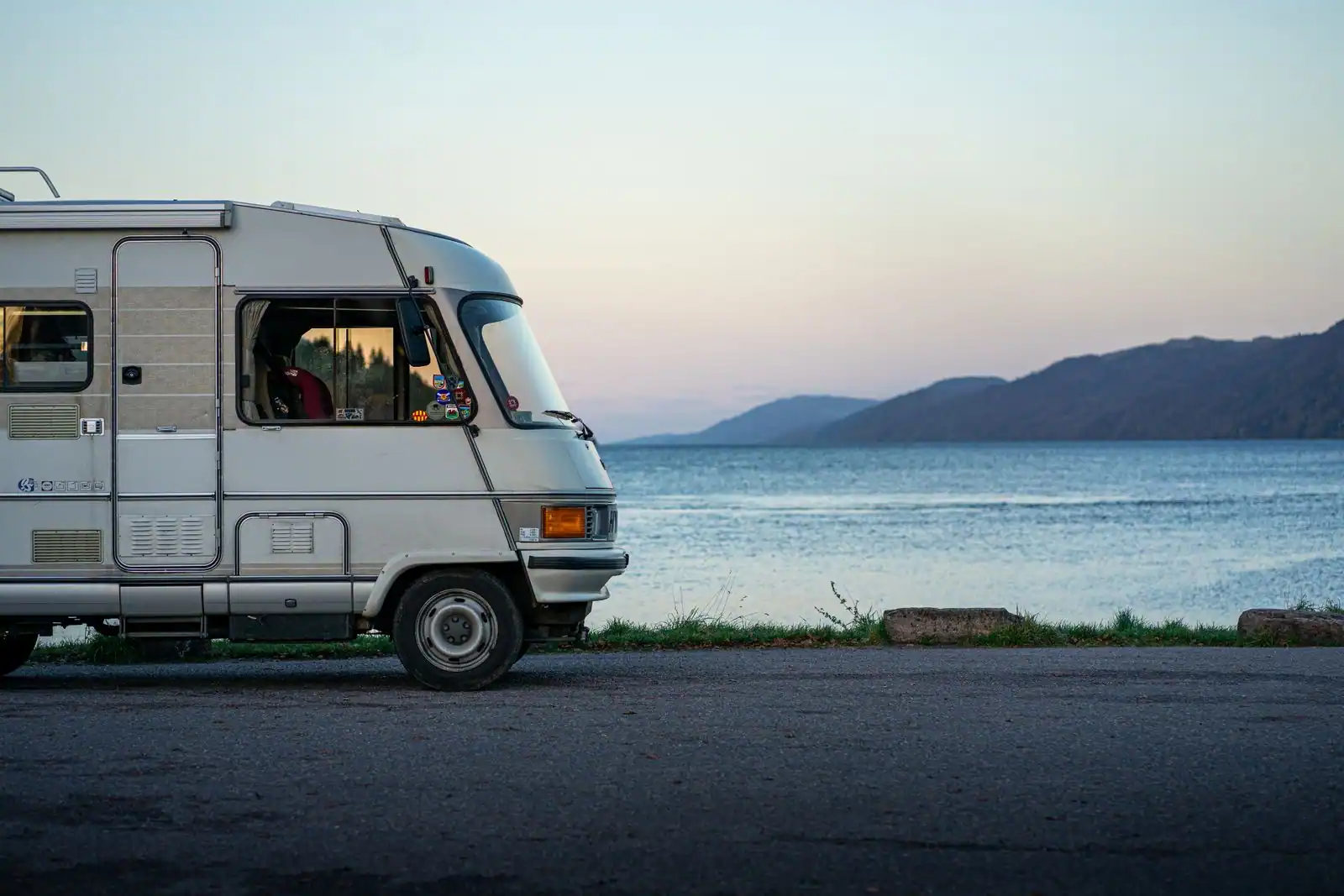 Camping-car garé face à un paysage de nature au coucher du soleil, illustration d'un voyage itinérant