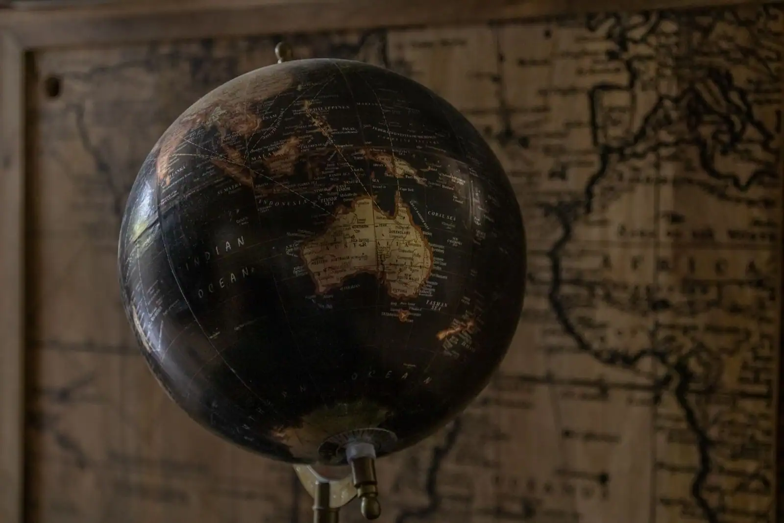 Gros plan sur un globe terrestre ancien couvert de noms de pays, évoquant le choix d'une destination