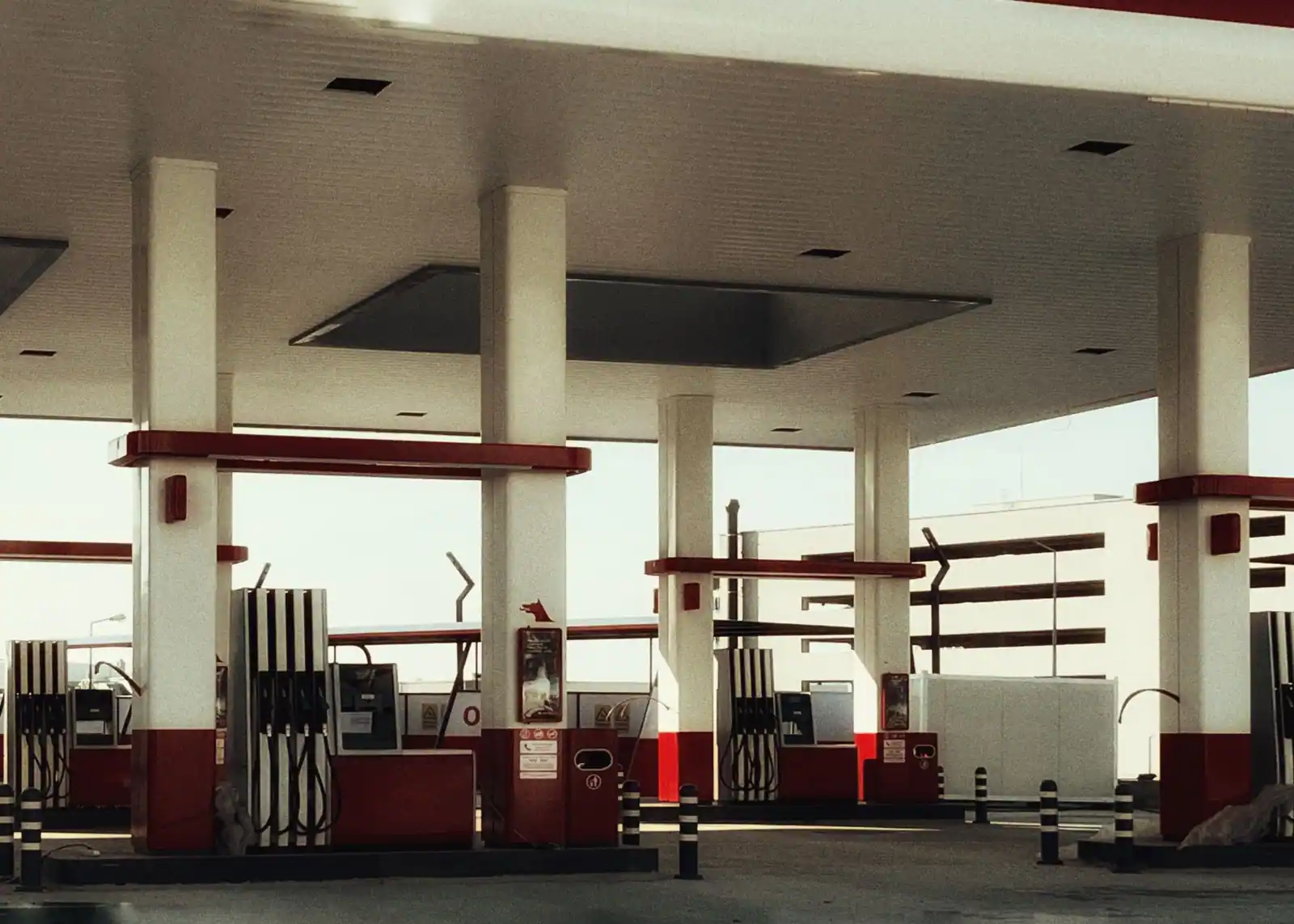 Îlots de pompes d'une station-service, avec plusieurs pistolets de carburant alignés sous l'auvent.