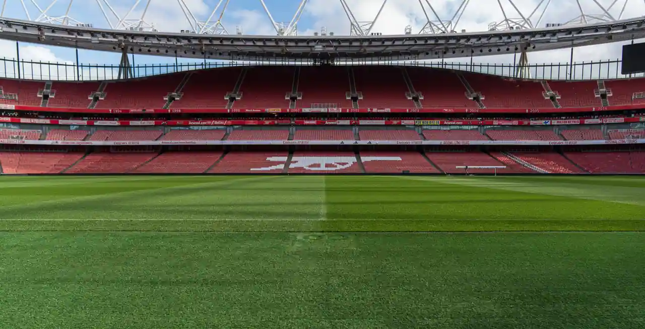 Tribunes rouges désertes et pelouse de l'Emirates Stadium, à Londres, un jour sans match.