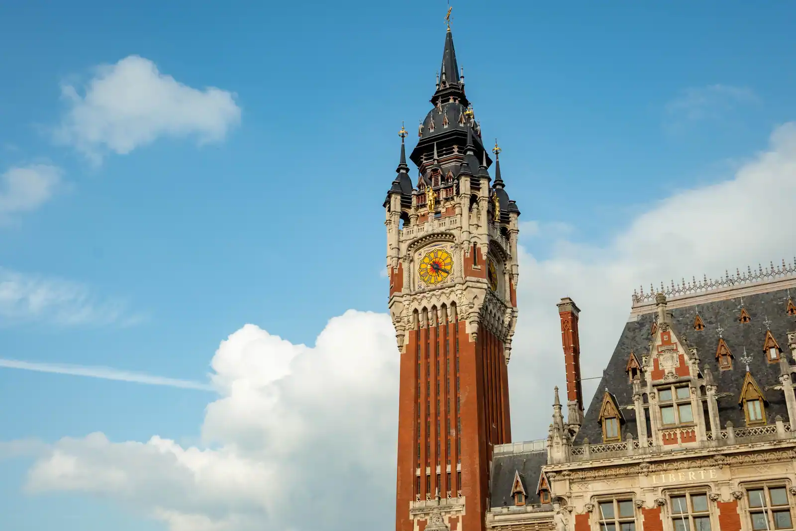 Le beffroi en brique de l'hôtel de ville de Calais et l'aile du bâtiment portant la devise Liberté.