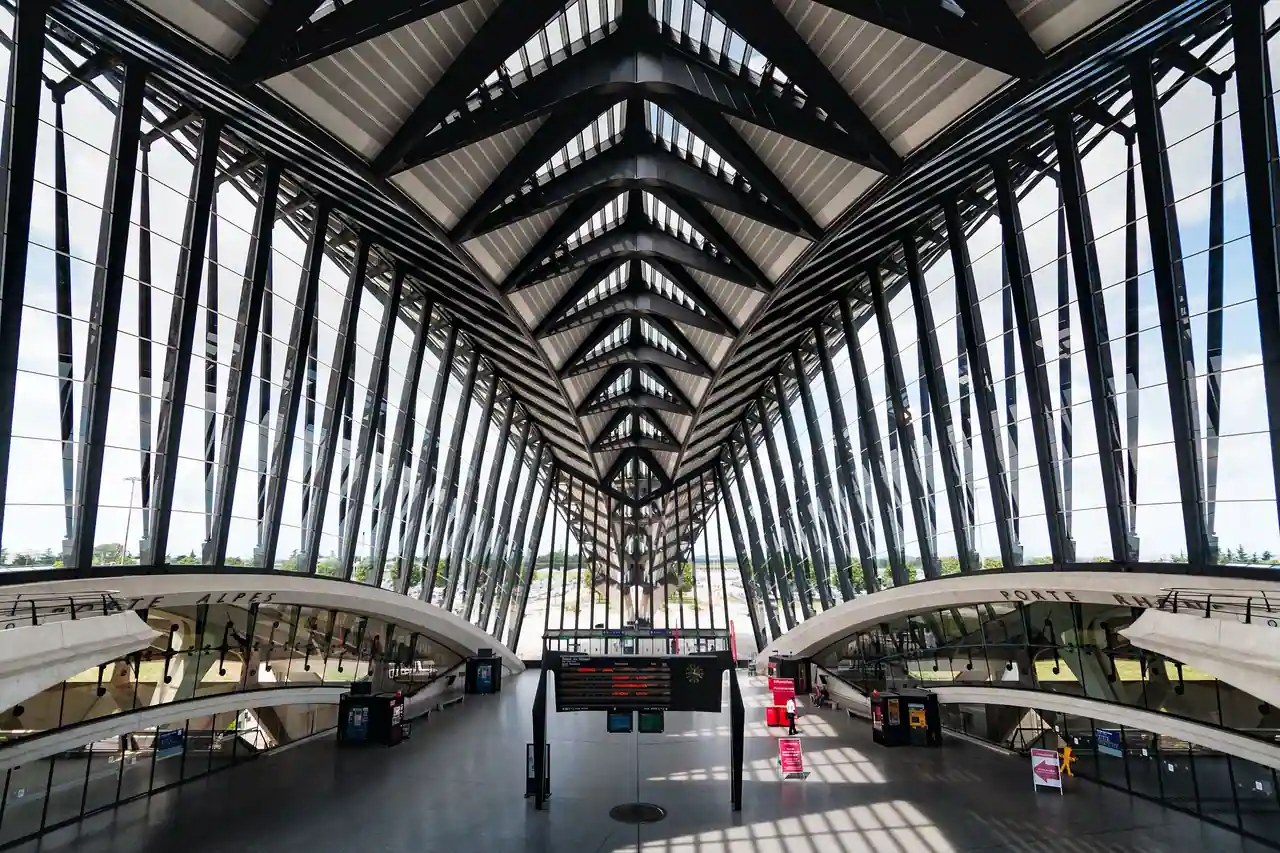 Halle de verre et d'acier de la gare de Lyon Saint-Exupéry TGV, tableau des départs au centre.