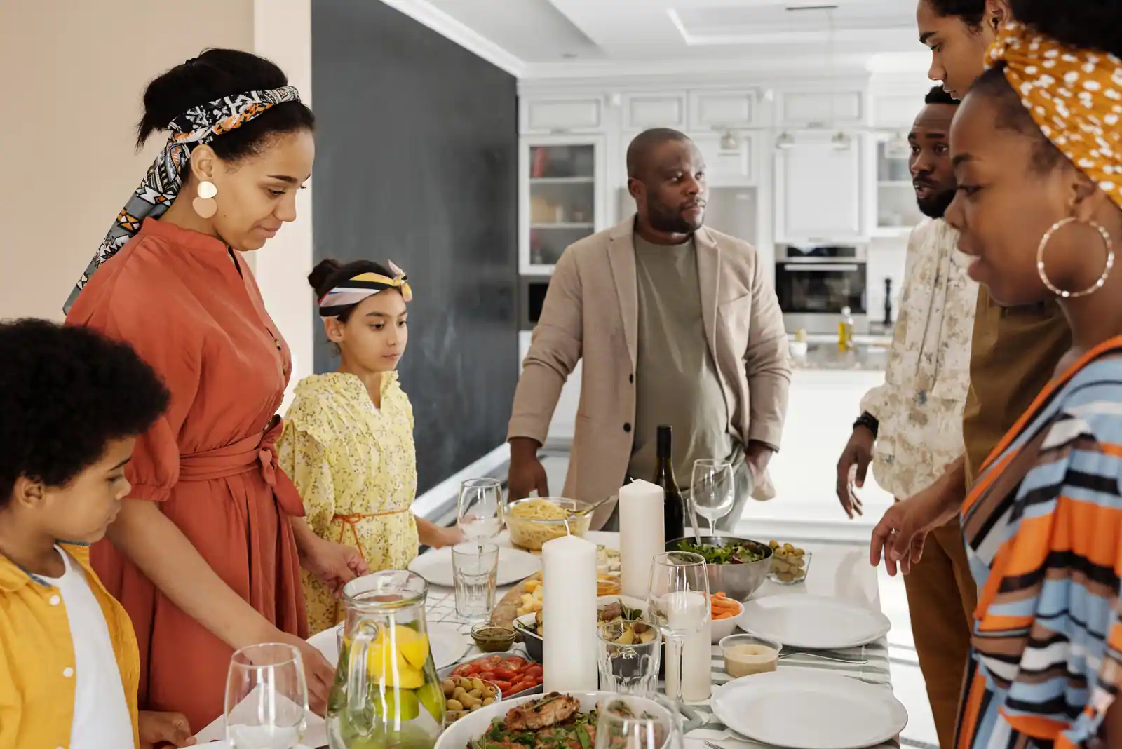 Repas de famille convivial autour d'une table généreusement dressée, dans une cuisine chaleureuse