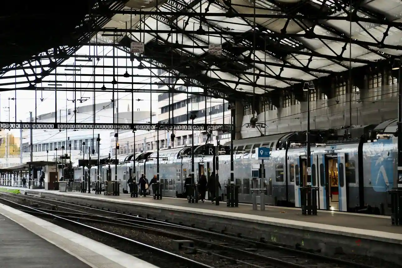 Rame de train régional moderne à quai, sous la verrière métallique d'une gare
