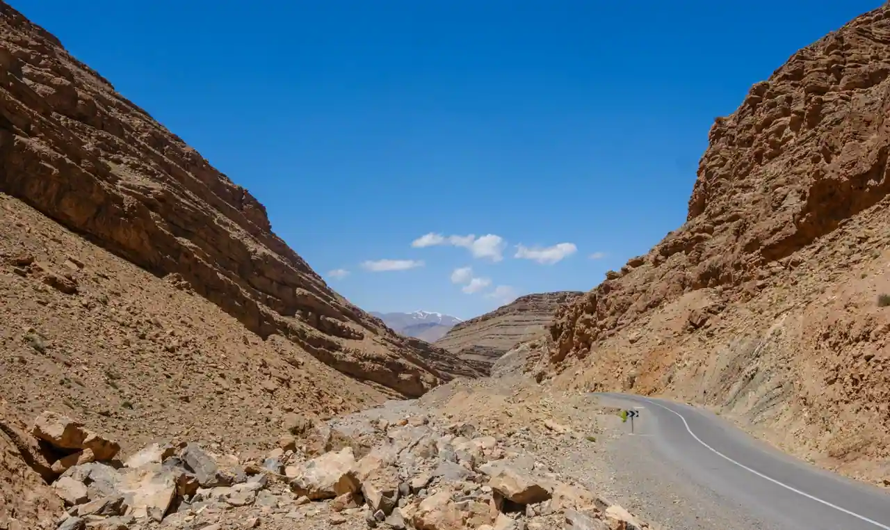 Une route sinueuse traverse un défilé rocheux des montagnes de l'Atlas, au Maroc.